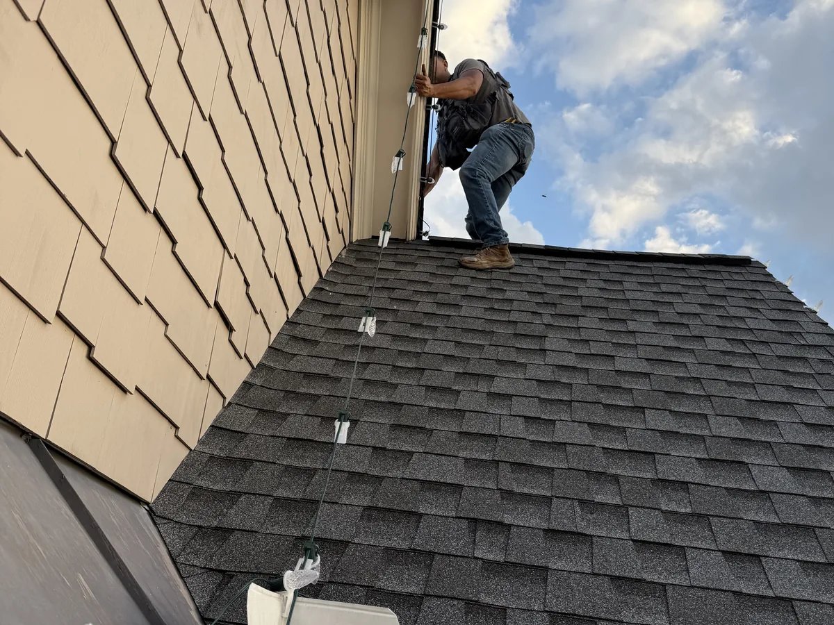 Bright Lights GA installer fitting Christmas lights along a roofline