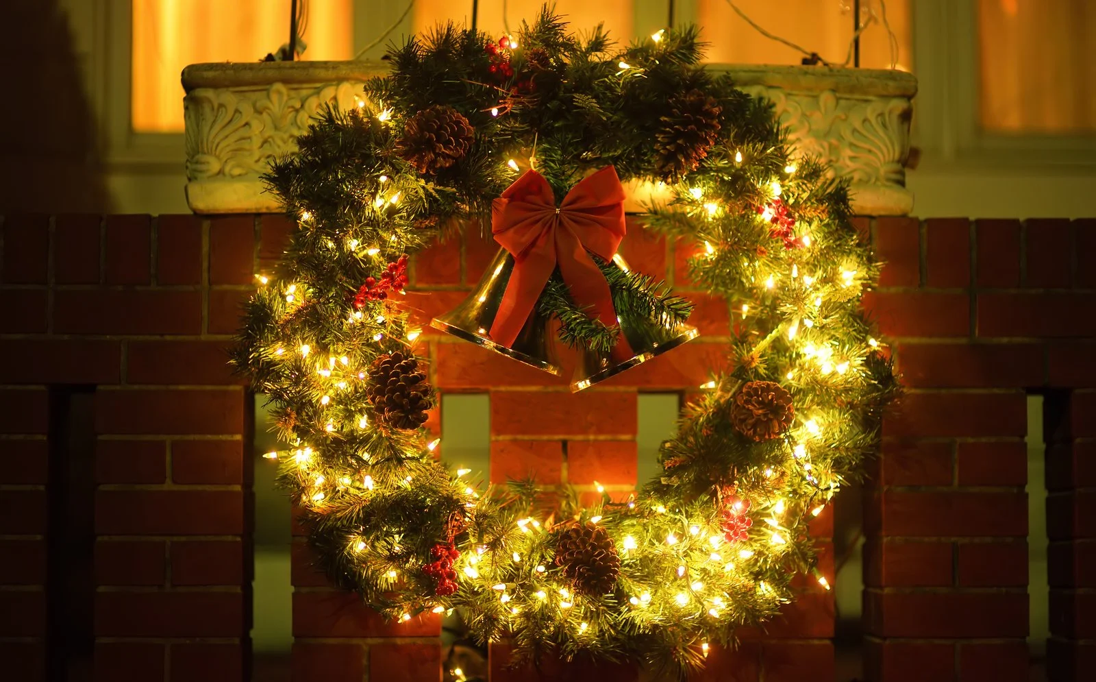 Lit holiday wreaths and garland accenting a home